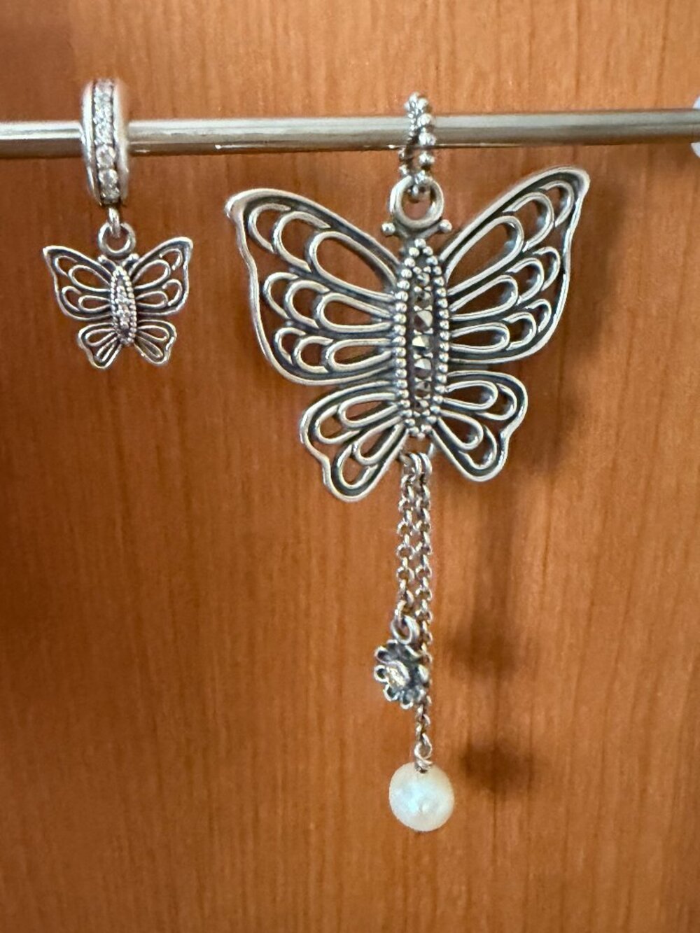 Pandora Butterfly Love Takes Flight silver pendant and matching bracelet dangle.